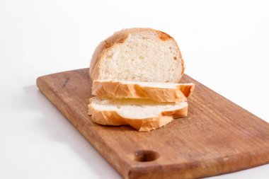 Mutfak tahtası, beyaz bir arka plan üzerinde beyaz ekmek dilimleri yan görünüm.