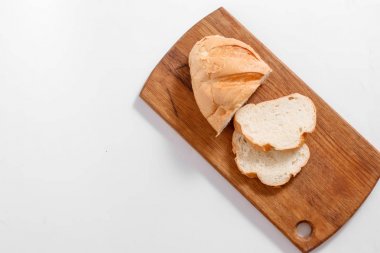 Dilim beyaz ekmek en iyi görünümü mutfak tahtası, beyaz bir arka plan üzerinde.