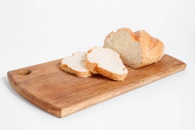 Mutfak tahtası, beyaz bir arka plan üzerinde beyaz ekmek dilimleri yan görünüm.