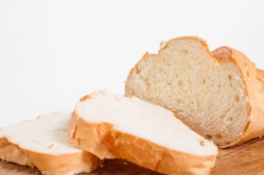 Mutfak tahtası, beyaz bir arka plan üzerinde beyaz ekmek dilimleri yan görünüm.