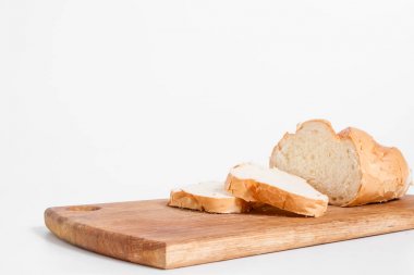 Mutfak tahtası, beyaz bir arka plan üzerinde beyaz ekmek dilimleri yan görünüm.