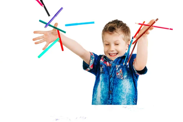 一个6岁的男孩在一个蓝色的衬衫 Tosss 铅笔上的白色背景隔离 — 图库照片