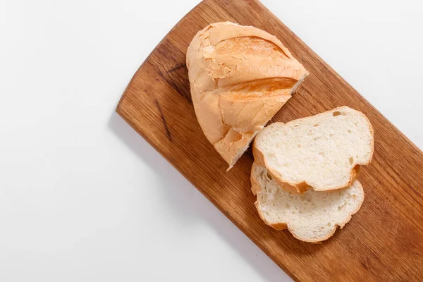 Dilim beyaz ekmek en iyi görünümü mutfak tahtası, beyaz bir arka plan üzerinde.