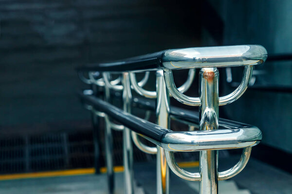 Metal fence made of chrome with handrails. Chromed metal railings. Shallow depth of field.