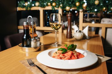 Bir restoranda bir masada beyaz tabakta domatesli makarna tagliatelle. Sofra Restaurant.