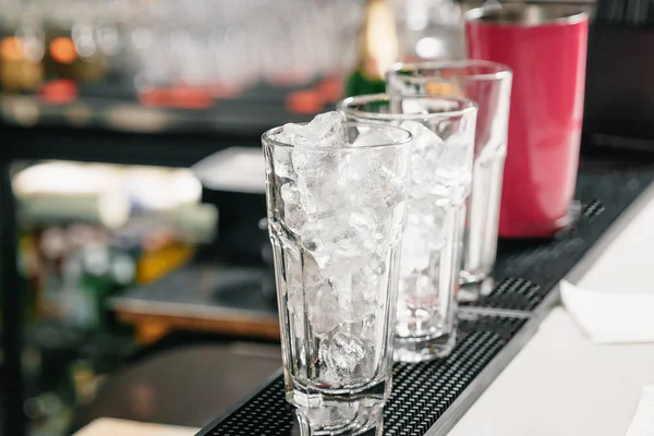 Leere, hohe Eisgläser auf der Theke. Cocktailzubereitung, Shaker. — Stockfoto
