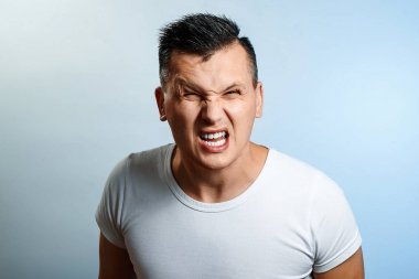 Öfke, nefret, hafif bir arka plan karşı yaşandığı bir adam yakın çekim portresi. İnsan duyguları kavramı.