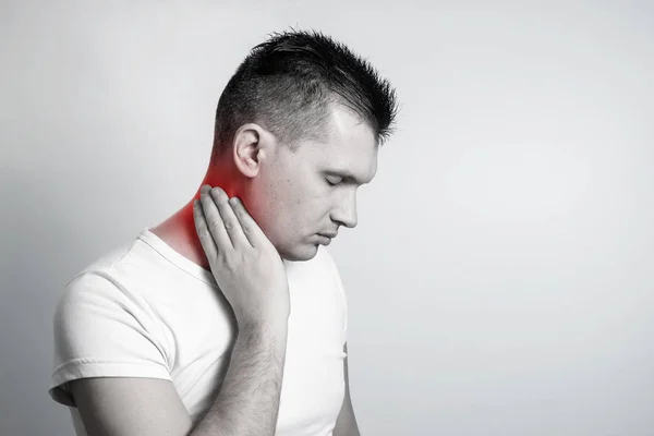 Porträtt av en man på en ljus bakgrund, smärta i nacken. — Stockfoto
