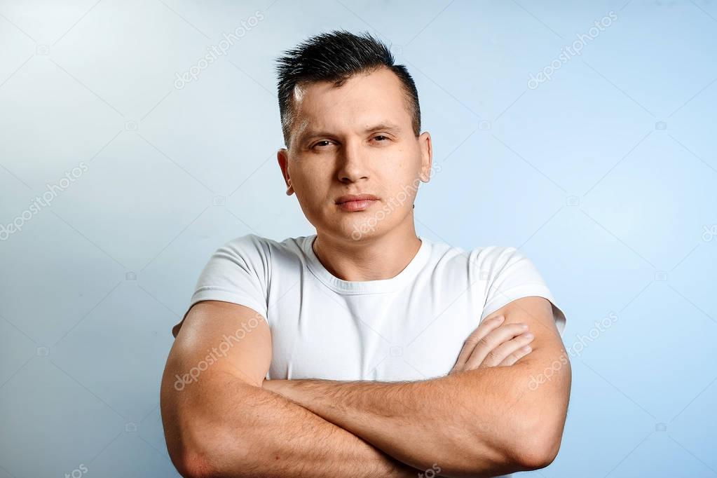 Portrait of a man on a light background close-up. Emotion is the importance, the superiority. The concept of body language, human emotions, reaction.