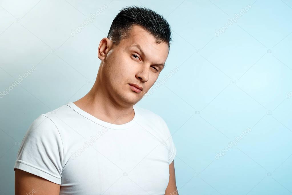 Portrait of a man on a light background close-up. Emotion is the importance, the superiority. The concept of body language, human emotions, reaction.