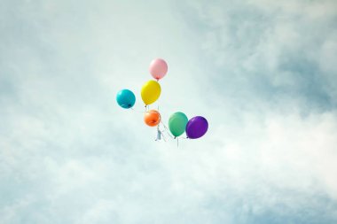 Grup çok renkli helyum balonlar gökyüzünde dolu