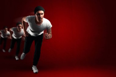 Mavi spor giyim kırmızı arka plan kopya alanı üzerinde çalışan adam