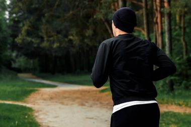 Park, park kopya alanı çalışan siyah spor elbiseli bir adam sabah dürtmek