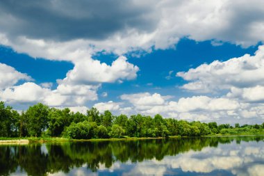 Güzel bir yaz kırsalında nehir ve mavi gökyüzünde bulutlar. - Rusya. Ural. Sloboda Köyü