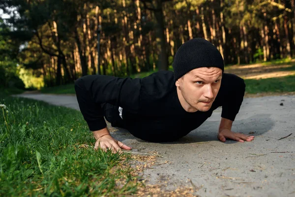 Bir adam bir yaz sabah kopya alanı üzerinde yeşil bir parkta sabah egzersiz için hazırlık egzersizleri yapıyor