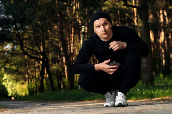 Bir adam bir yaz sabah kopya alanı üzerinde yeşil bir parkta sabah egzersiz için hazırlık egzersizleri yapıyor