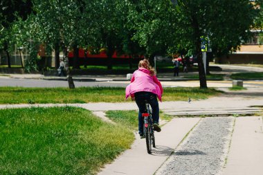 Kız bir adamla bir parkta bir bisiklet sürme