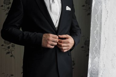 Mavi elbiseli bir adam kollarını düzeltiyor