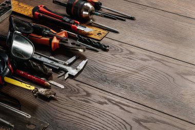 İnşaat aracı kahverengi ahşap arka plan üzerinde. Yukarıdan görüntüleyin. Resim arka plan, ekran koruyucu. İnşaat, onarım, inşaat, üretim, tasarım kavramı. Kopya alanı.