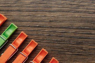 Bir yeşil, keten clothespin üst üste ahşap arka plan üzerinde turuncu, keten clothespins dönüştürün. Yaratıcı görüntü arka plan. Kavramı herkes gibi başka bir serseri değil başka bir.