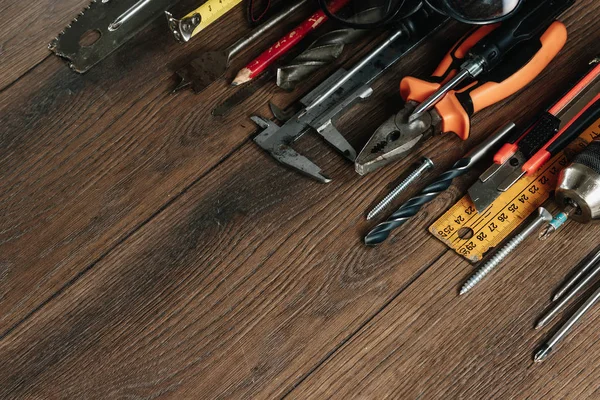 İnşaat aracı kahverengi ahşap arka plan üzerinde. Yukarıdan görüntüleyin. Resim arka plan, ekran koruyucu. İnşaat, onarım, inşaat, üretim, tasarım kavramı. Kopya alanı.