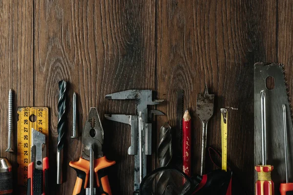 İnşaat aracı kahverengi ahşap arka plan üzerinde. Yukarıdan görüntüleyin. Resim arka plan, ekran koruyucu. İnşaat, onarım, inşaat, üretim, tasarım kavramı. Kopya alanı.