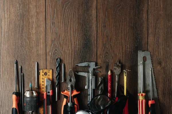 İnşaat aracı kahverengi ahşap arka plan üzerinde. Yukarıdan görüntüleyin. Resim arka plan, ekran koruyucu. İnşaat, onarım, inşaat, üretim, tasarım kavramı. Kopya alanı.