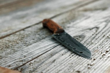 Kahverengi saplı bir bıçak bir ahşap gri arka plan üzerinde yatıyor. Kopya alanı.