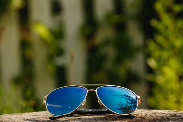 Sonnenbrille Liegt Auf Holztisch Auf Naturhintergrund — Stockfoto