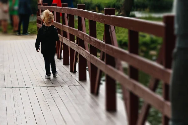 Dziewczynka Drewniany Most Powrotem Aparatu Parku Zachodzie Słońca — Zdjęcie stockowe