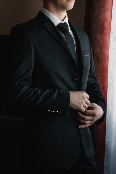 A man buttoning a blue jacket