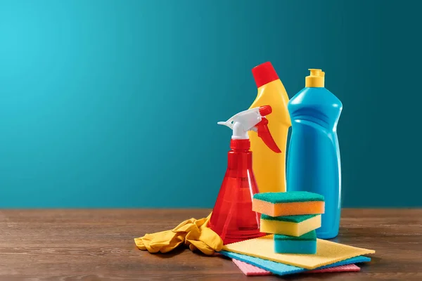 Image with various tools for cleaning the premises and cleaning agents on a blue background. The concept of cleaning the premises, cleanliness.