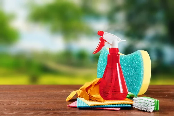 Image with various tools for cleaning the premises and cleaning agents on a blurred natural background. The concept of cleaning the premises, cleanliness.