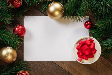 Çamın dalları ve yılbaşı süsleri ve A4 sayfa ahşap bir masa üzerinde white Paper bir çerçeve. Tatil Noel arka plan. Metin veya tasarım için alan kopyalayın. Yukarıdan görüntülemek.