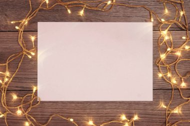 Çamın dalları ve yılbaşı süsleri ve A4 sayfa ahşap bir masa üzerinde white Paper bir çerçeve. Tatil Noel arka plan. Metin veya tasarım için alan kopyalayın. Yukarıdan görüntülemek.