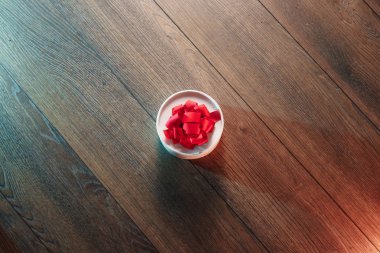 Kahverengi hediye kutusu ve kırmızı kurdele ile etiket alanına sahip ahşap arka plan üzerinde yukarıda görüntülemek.