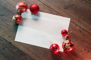 Çamın dalları ve yılbaşı süsleri ve A4 sayfa ahşap bir masa üzerinde white Paper bir çerçeve. Tatil Noel arka plan. Metin veya tasarım için alan kopyalayın. Yukarıdan görüntülemek.
