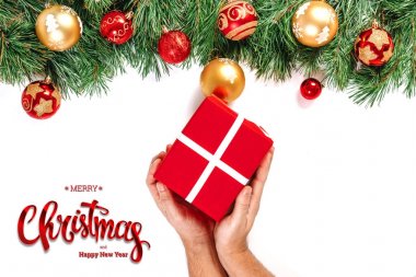 Hediye, yazıt neşeli Noel ve mutlu yeni yıl ve yeşil Ladin beyaz bir arka plan üzerinde holding eller. Noel kartı, Festival arka plan. Karışık teknik.