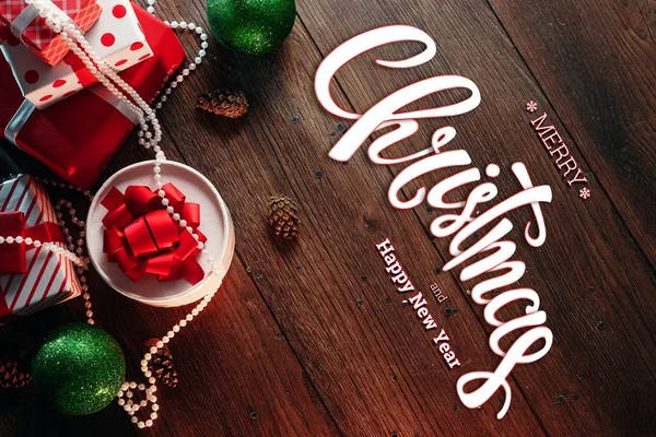 圣诞快乐和新年的题词 装饰和礼物在一个木褐色的桌子上 圣诞贺卡 节日背景 混合媒体 — 图库照片