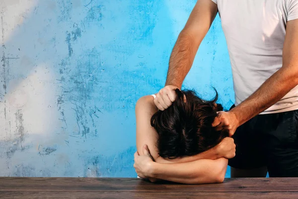 Homem Zomba Uma Mulher Contra Uma Parede Azul Conceito Violência — Fotografia de Stock