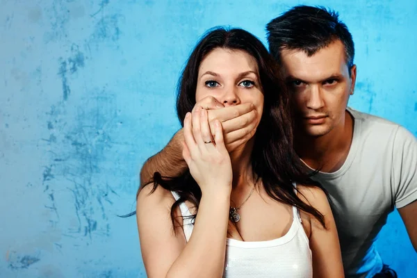 Seorang Pria Menutup Mulutnya Terhadap Seorang Wanita Terhadap Dinding Biru — Stok Foto