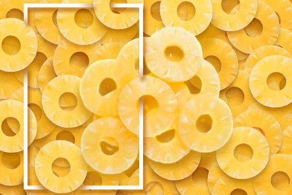 Yellow, fruity background of pineapple rings and white frame. Natural background, fresh fruits.