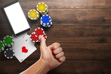 Online casino mobil casino, bir cep telefonu, en iyi görünümünü kartları bir ahşap arka plan üzerinde fişleri. Kumar Oyunları.