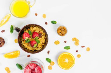 Mısır gevreği, sabah kahvaltı, Mısır gevreği, Kuru üzüm, badem, nane yaprağı, portakal suyu, çilek, üstten görünüm, beyaz arka plan, düz yatıyordu. Sağlıklı, doğru beslenme, ditox kavramı.