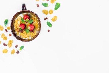 Mısır gevreği, sabah kahvaltı, Mısır gevreği, Kuru üzüm, badem, nane yaprağı, çilek, üstten görünüm, beyaz arka plan, düz yatıyordu. Sağlıklı, doğru beslenme, ditox kavramı.