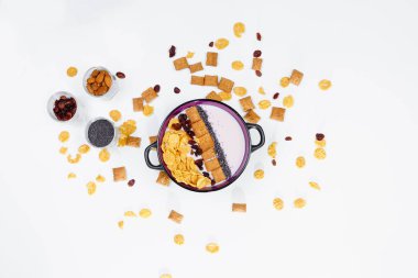 Sabah kahvaltı. Ev yapımı yoğurt ve Mısır gevreği, Kuru üzüm, badem beyaz arka plan, üstten görünüm, düz lay ile top. Sağlıklı gıda, sağlıklı gıda, detoks kavramı. Kopya alanı