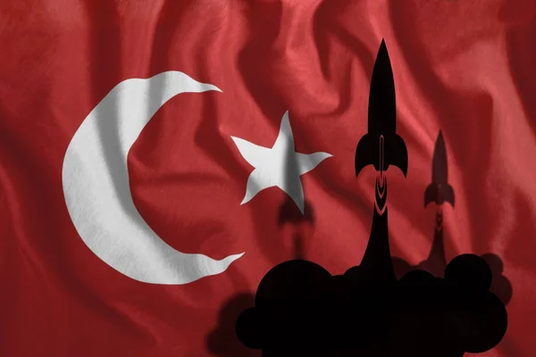 Cohetes voladores contra el fondo de la bandera turca ondeando en el viento. Colorida bandera nacional de Turquía. Patriotismo, símbolo patriótico, guerra, conflicto . — Foto de Stock