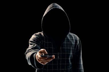 Siluet siyah bir arka plan, yüzünü bir kaputa bir adamın görünür değil, hacker telefon elinde tutuyor. Bir suçlu, gizli, gizem, gizlilik, gizlilik kavramı.