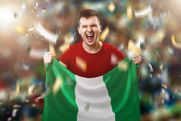 Nijeryalı bir fan, Nijerya ulusal bayrak onun elinde tutan bir adam hayranı. Stadyumda futbol hayranı. Karışık teknik — Stok fotoğraf