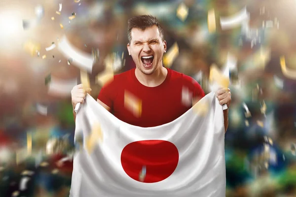 Japon hayranı, a yelpaze-in Japonya Ulusal bayrak onun elinde tutan bir adam. Stadyumda futbol hayranı. Karışık teknik — Stok fotoğraf